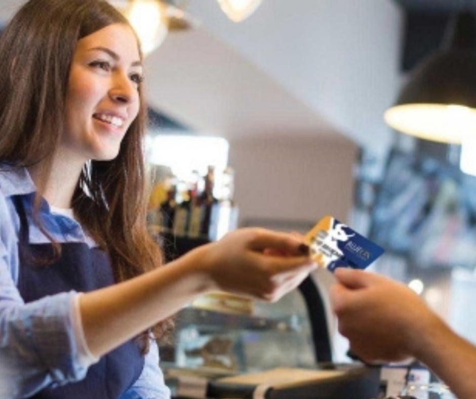 Coffee shop employee handing a credit card back to the customer. 