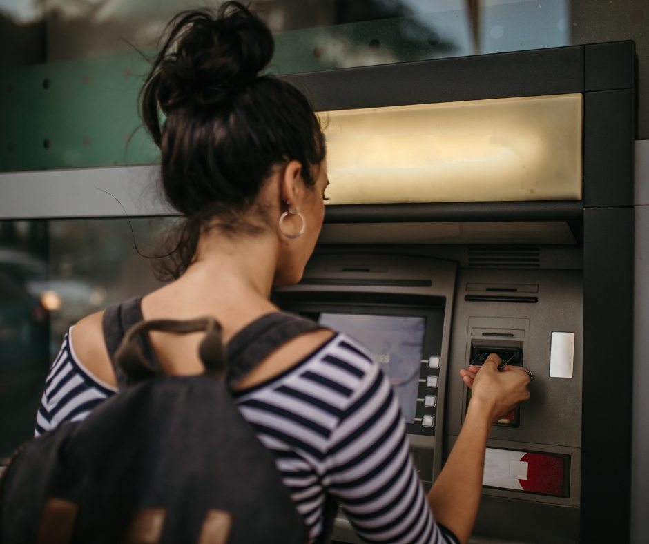 Woman using her card at an ATM. 